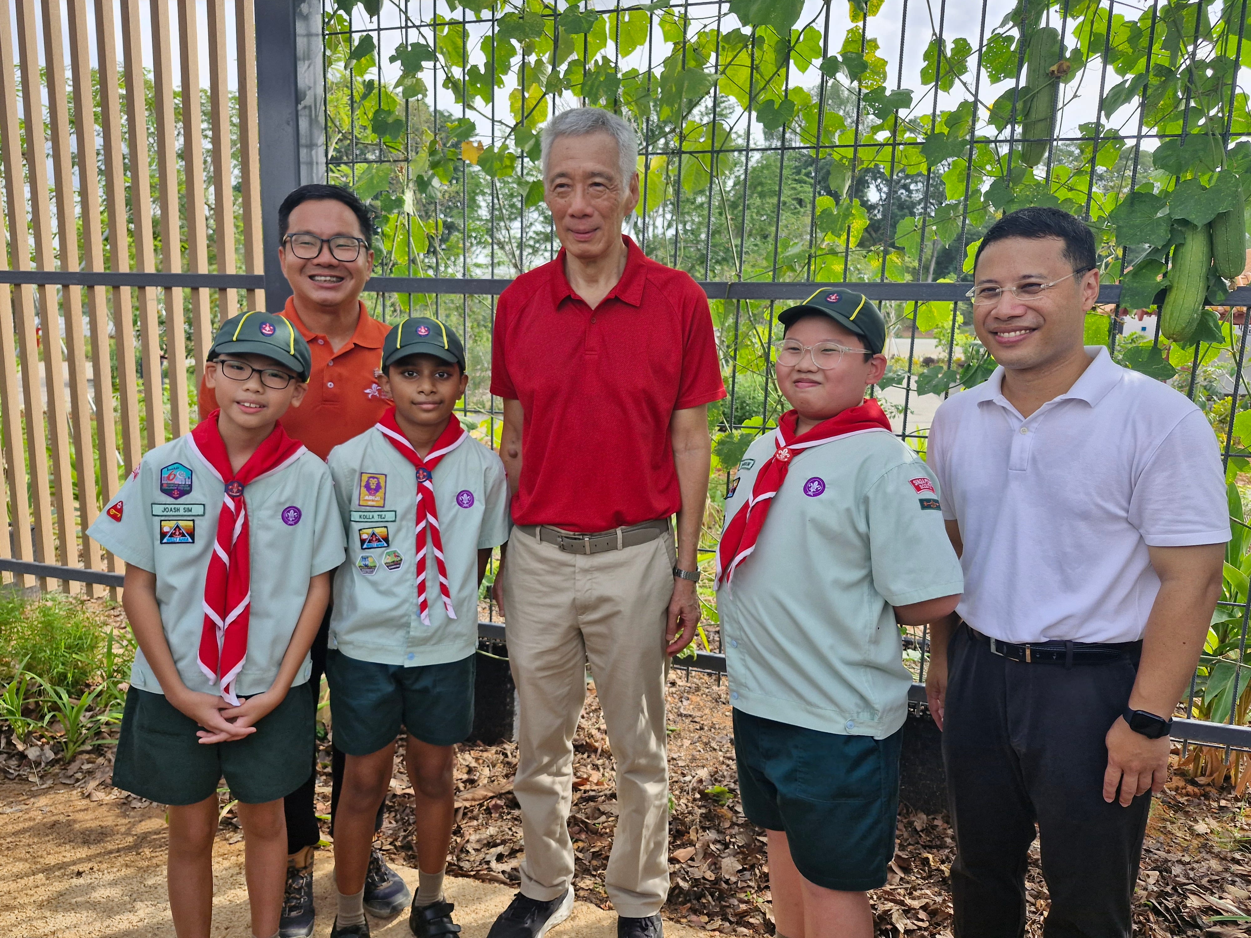 Frontier Primary School Scouts with school staff and community representatives at Jurong Lake Gardens, celebrating their participation in an environmental and community engagement experience.